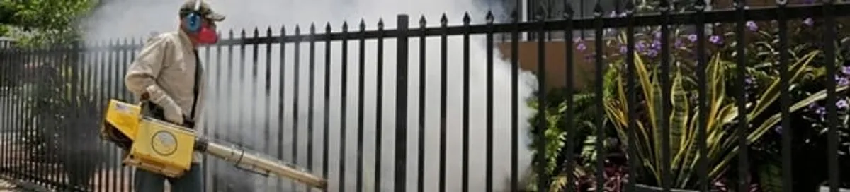 Mosquito control technician fogging a yard perimeter for mosquito reduction in Jersey City, NJ